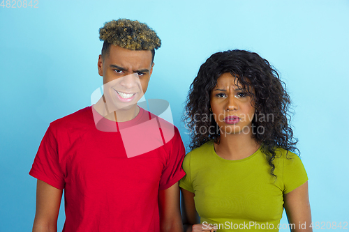 Image of Young emotional african-american man and woman on blue background