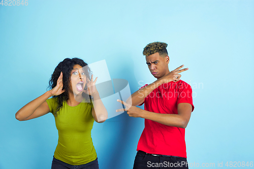 Image of Young emotional african-american man and woman on blue background