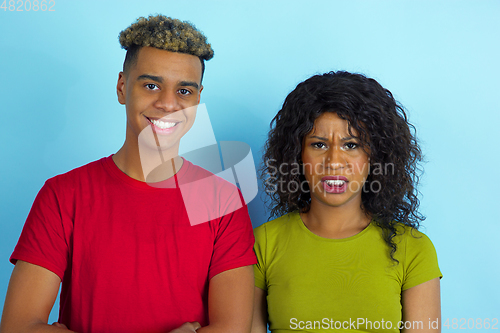 Image of Young emotional african-american man and woman on blue background