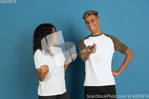 Image of Young emotional african-american man and woman on blue background