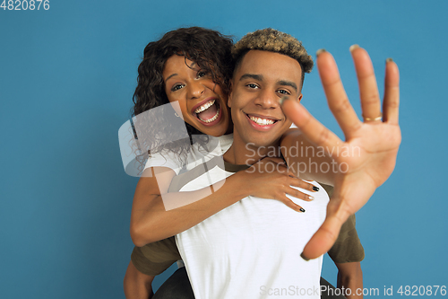 Image of Young emotional african-american man and woman on blue background