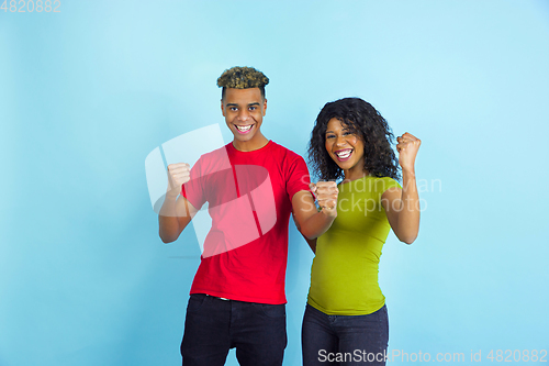 Image of Young emotional african-american man and woman on blue background