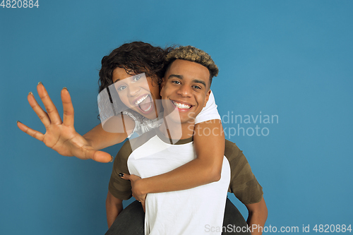 Image of Young emotional african-american man and woman on blue background