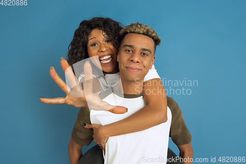 Image of Young emotional african-american man and woman on blue background