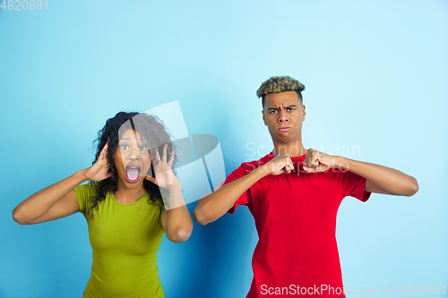 Image of Young emotional african-american man and woman on blue background