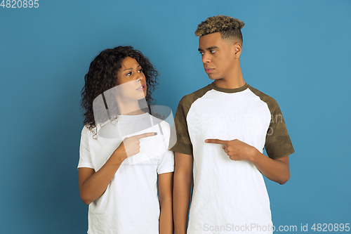 Image of Young emotional african-american man and woman on blue background