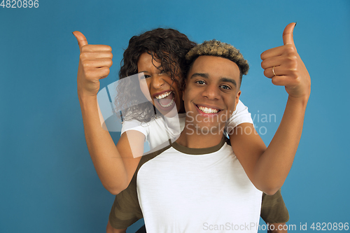 Image of Young emotional african-american man and woman on blue background