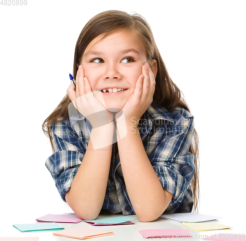 Image of Girl is writing on color stickers using pen