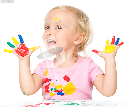 Image of Portrait of a cute little girl playing with paints