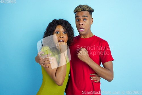 Image of Young emotional african-american man and woman on blue background
