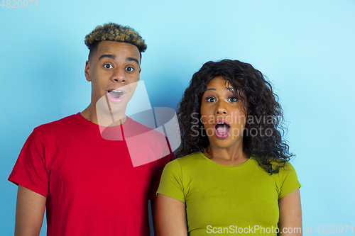 Image of Young emotional african-american man and woman on blue background