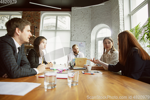Image of Group of young business professionals having a meeting, creative office