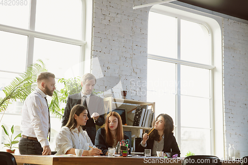 Image of Group of young business professionals having a meeting, creative office