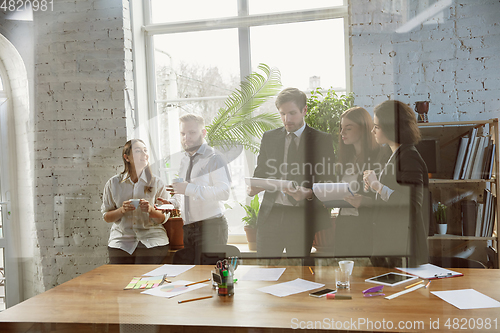 Image of Group of young business professionals having a meeting, creative office