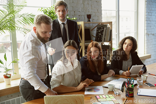 Image of Group of young business professionals having a meeting, creative office