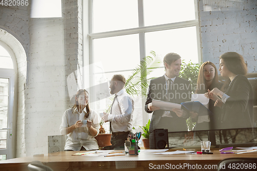 Image of Group of young business professionals having a meeting, creative office