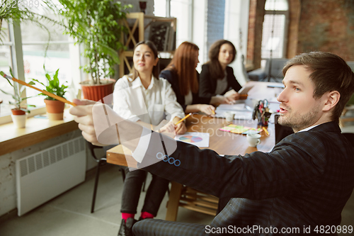 Image of Group of young business professionals having a meeting, creative office