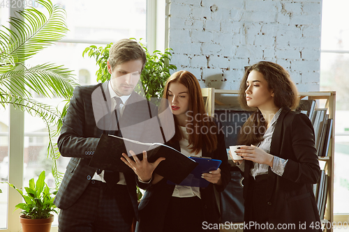 Image of Group of young business professionals having a meeting, creative office