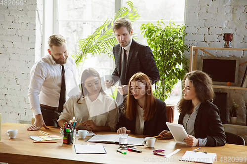 Image of Group of young business professionals having a meeting, creative office