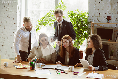 Image of Group of young business professionals having a meeting, creative office