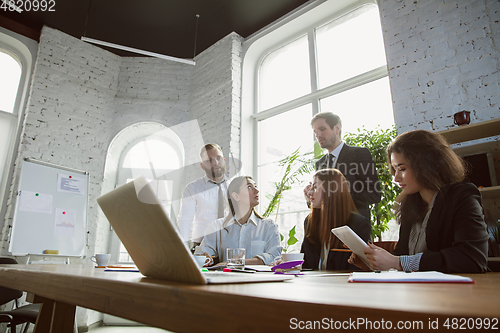 Image of Group of young business professionals having a meeting, creative office