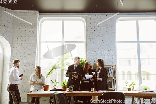 Image of Group of young business professionals having a meeting, creative office