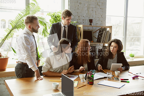 Image of Group of young business professionals having a meeting, creative office