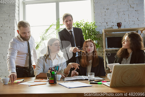 Image of Group of young business professionals having a meeting, creative office