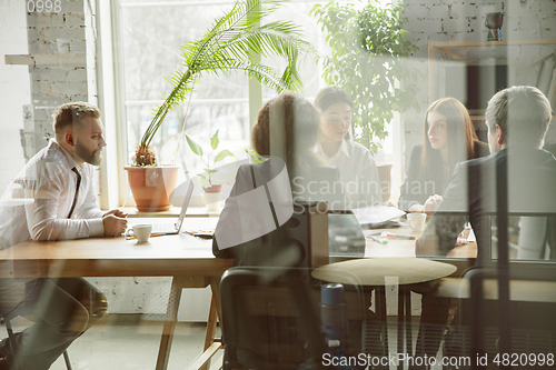 Image of Group of young business professionals having a meeting, creative office