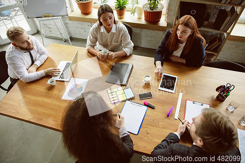 Image of Group of young business professionals having a meeting, creative office