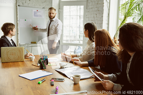 Image of Group of young business professionals having a meeting, creative office