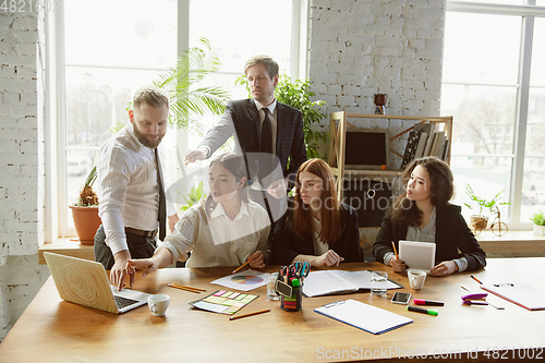 Image of Group of young business professionals having a meeting, creative office