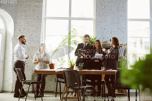 Image of Group of young business professionals having a meeting, creative office