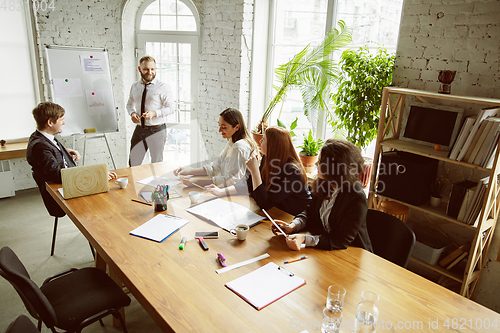 Image of Group of young business professionals having a meeting, creative office