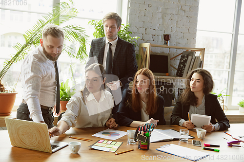 Image of Group of young business professionals having a meeting, creative office