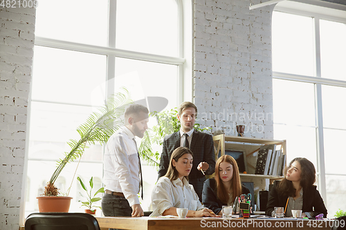 Image of Group of young business professionals having a meeting, creative office