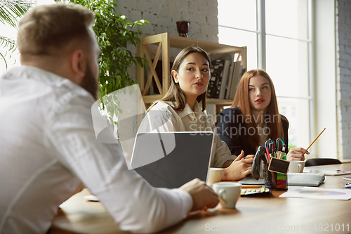 Image of Group of young business professionals having a meeting, creative office