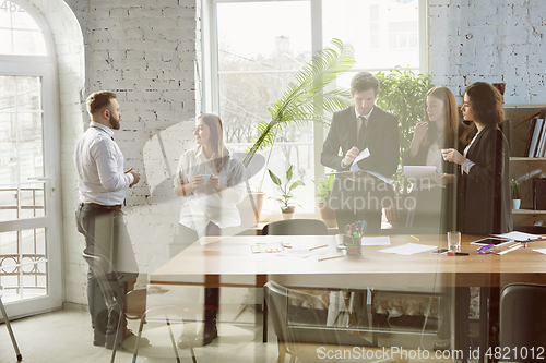 Image of Group of young business professionals having a meeting, creative office