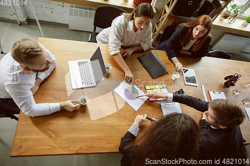 Image of Group of young business professionals having a meeting, creative office