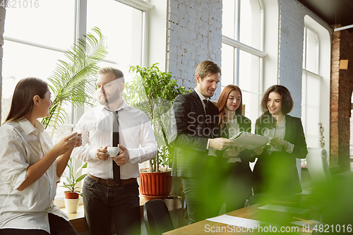 Image of Group of young business professionals having a meeting, creative office