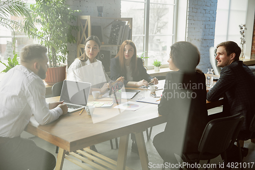 Image of Group of young business professionals having a meeting, creative office