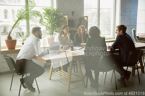 Image of Group of young business professionals having a meeting, creative office