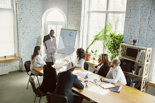 Image of Group of young business professionals having a meeting, creative office