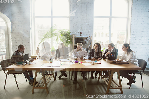 Image of Group of young business professionals having a meeting, creative office