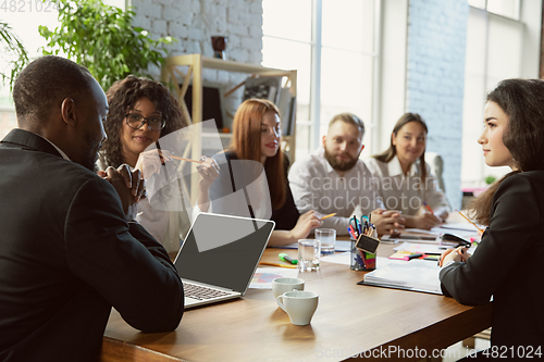 Image of Group of young business professionals having a meeting, creative office