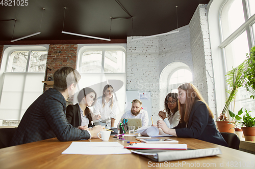 Image of Group of young business professionals having a meeting, creative office