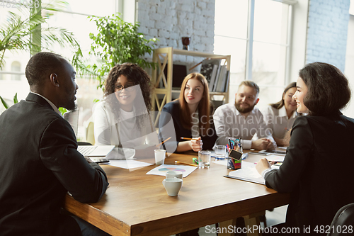 Image of Group of young business professionals having a meeting, creative office