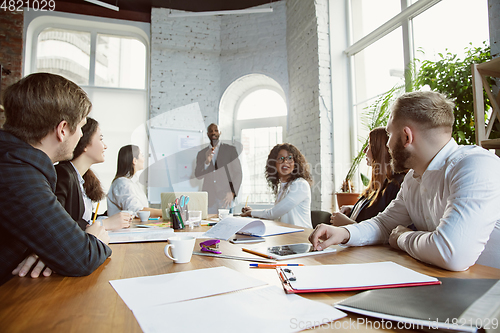 Image of Group of young business professionals having a meeting, creative office