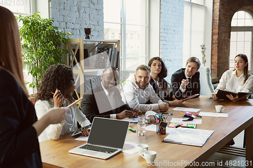 Image of Group of young business professionals having a meeting, creative office