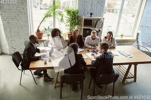 Image of Group of young business professionals having a meeting, creative office